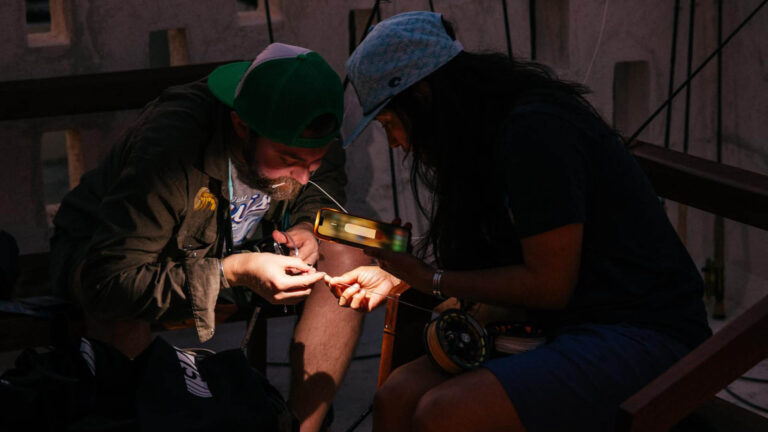 Two people working on their fly fishing rods.