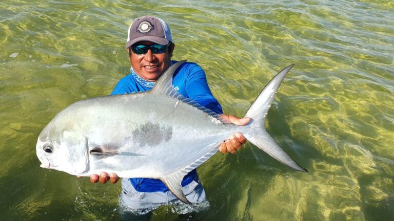 An inshore fly fishermen catches a permit in Ascension Bay, Mexico.