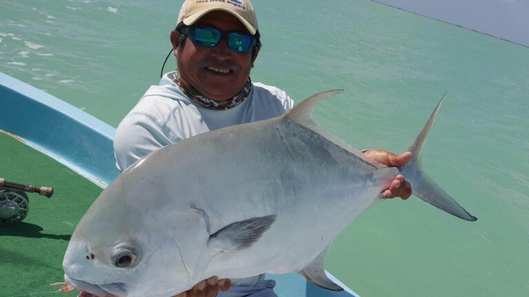 A fly fishermen catches a permit in Ascension Bay, Mexico.